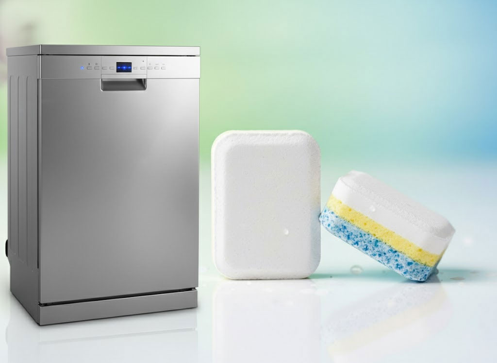 Viên rửa bát đặt cạnh máy đang hoạt động, đèn báo hiệu thời gian rút ngắn